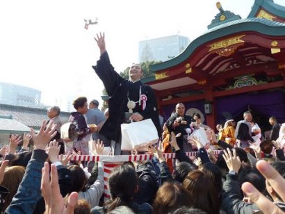 Kotoushu jetant des haricots pour setsubun au sanctuaire