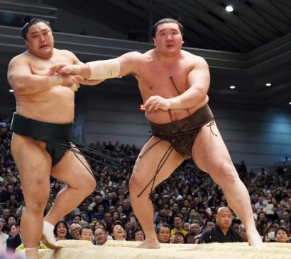 Hakuho "achève" Okinoumi en le poussant violemment hors du dohyô.