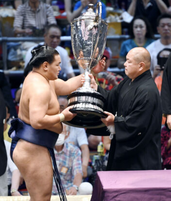Hoshoryu reçoit la Coupe de l'Empereur des mains du président de la NSK, Hakkaku, après avoir remporté son premier titre en makuuchi