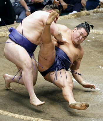 Aonishiki renverse le yokozuna Hoshoryu le 12ème jour de l'Aki Bashô au Ryogôku Kokugikan à Tokyô, jeudi 25 septembre 2025 (Kyodo)